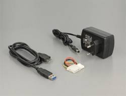 USB-Kabel, Netzteil und kleiner Steckverbinder auf einer grauen Oberfläche.