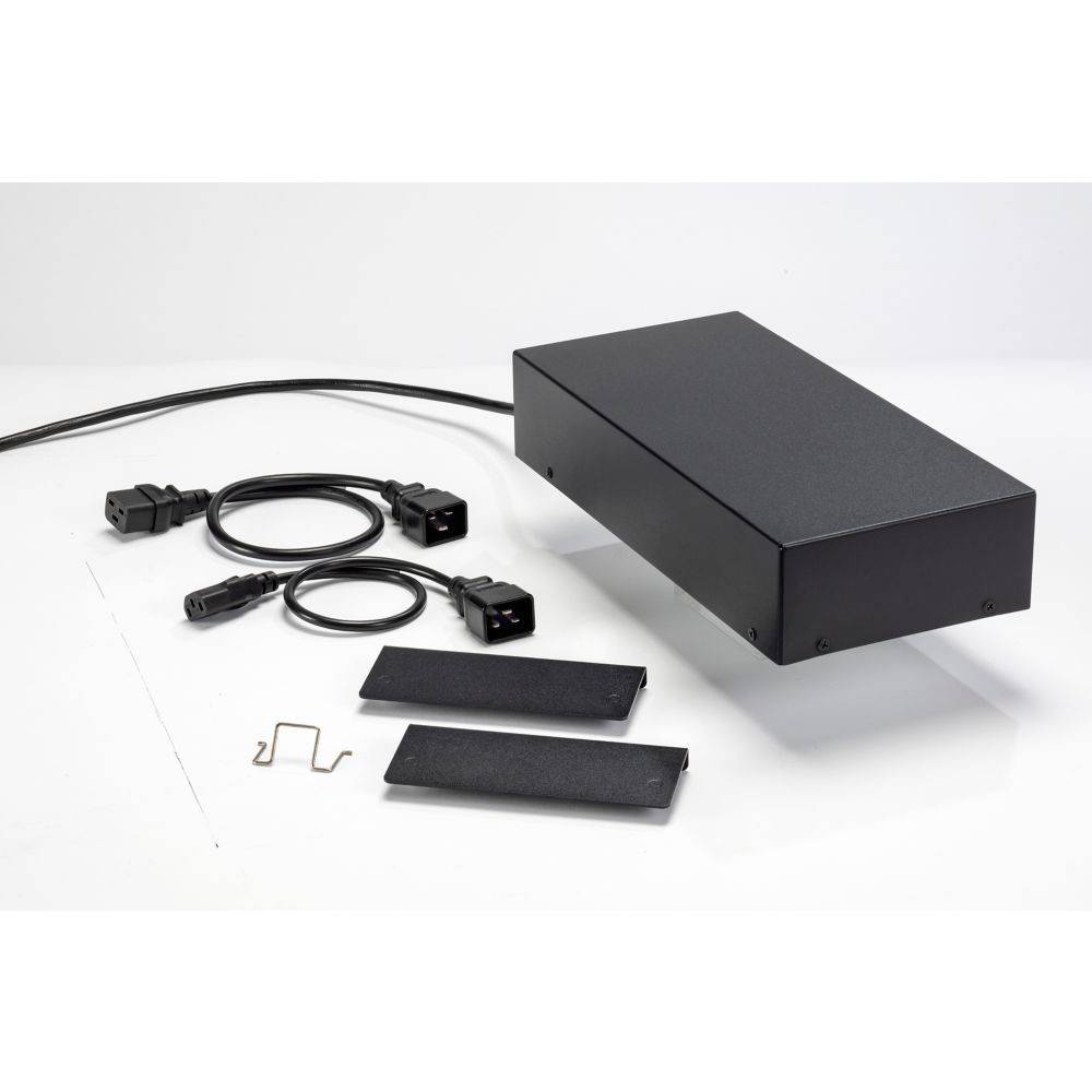 Schwarzes rechteckiges elektronisches Gerät mit Kabeln, Anschlüssen und zwei rechteckigen Metallplatten auf einer weißen Oberfläche.