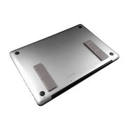 Unterseite eines silbernen Laptops, die vier schwarze Gummifüße und einen langen Lüftungsschlitz in der Nähe der hinteren Kante zeigt.