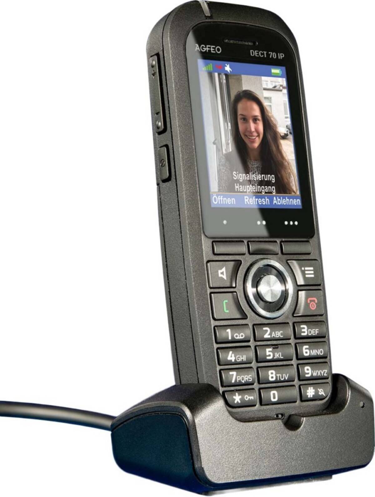 Schwarzes schnurloses Schreibtischtelefon auf Ladestation, mit farbigem Bildschirm, der einen eingehenden Videoanruf von einer lächelnden Frau mit deutschen Anrufoptionen anzeigt.