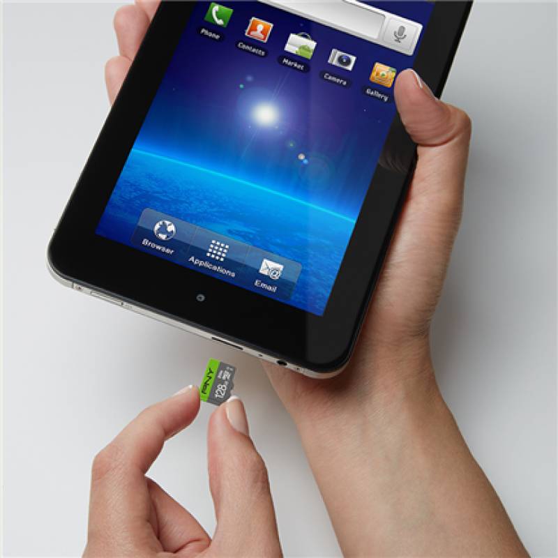 Hände, die ein Tablet halten, während eine microSD-Karte in den seitlichen Steckplatz eingeführt wird, was auf eine Speichererweiterung des Geräts hindeutet.