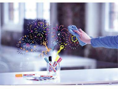 Eine Hand wischt eine Glasoberfläche sauber und enthüllt dabei farbenfrohe Feuerwerkszeichnungen dahinter, mit Markern und Reinigungsmitteln auf einem Tisch.