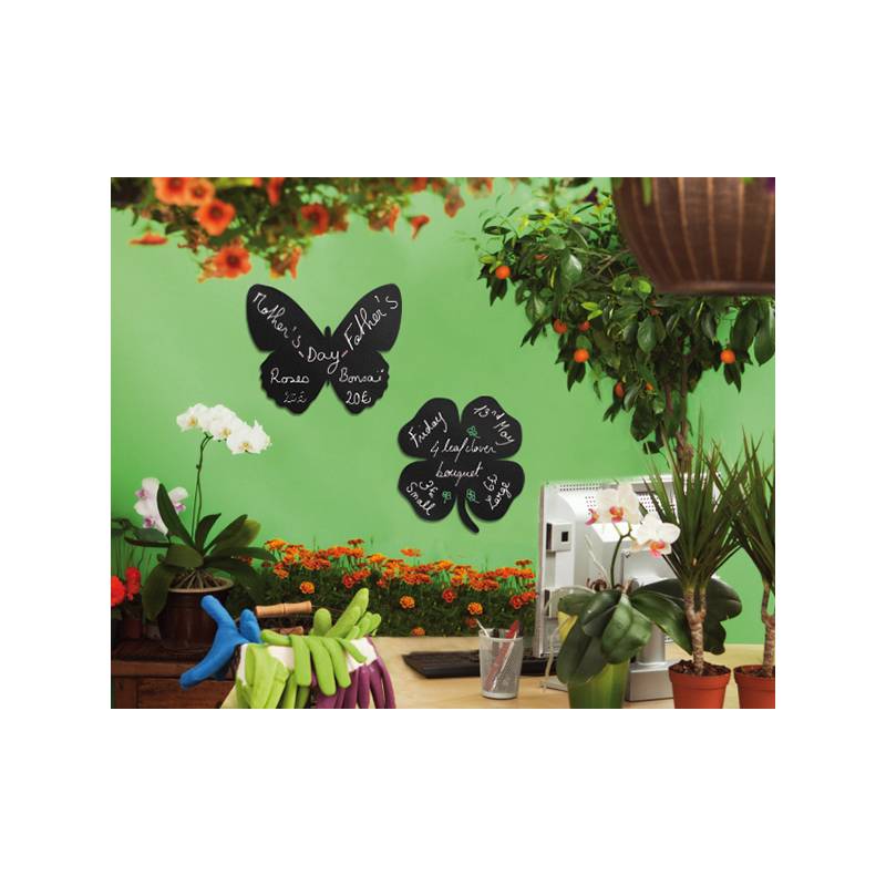 Ein lebendiger Blumenladen präsentiert eine grüne Wand, die mit Kreidetafel-Blumenformen geschmückt ist, auf denen handschriftlich Preise und Namen von Blumensträußen stehen.