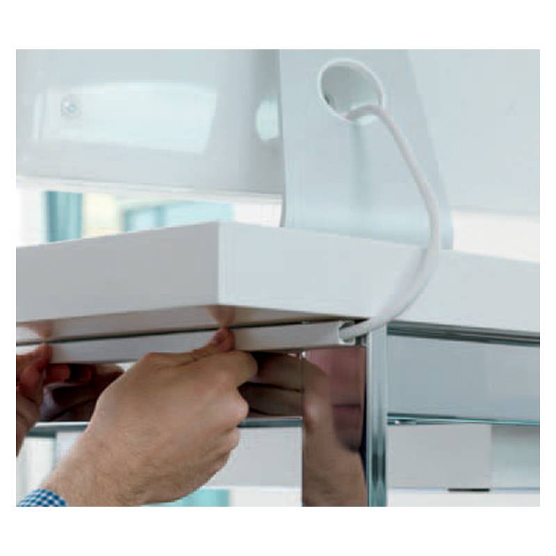 Hände justieren ein weißes Panel mit verbundenen Kabeln in einem modernen Schrank, was auf eine Installations- oder Wartungsaufgabe hindeutet.