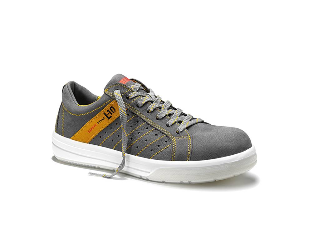 Ein grauer Sneaker mit gelben Nähten, weißer Sohle und grauen Schnürsenkeln. Die Seite zeigt den Text 'Safety Style L10' in Schwarz und Orange.