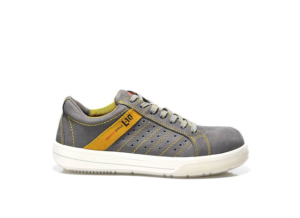 Ein grau-gelber Turnschuh mit dekorativer Stickerei, an dessen Seite der Text ‚safety style 40' zu sehen ist.