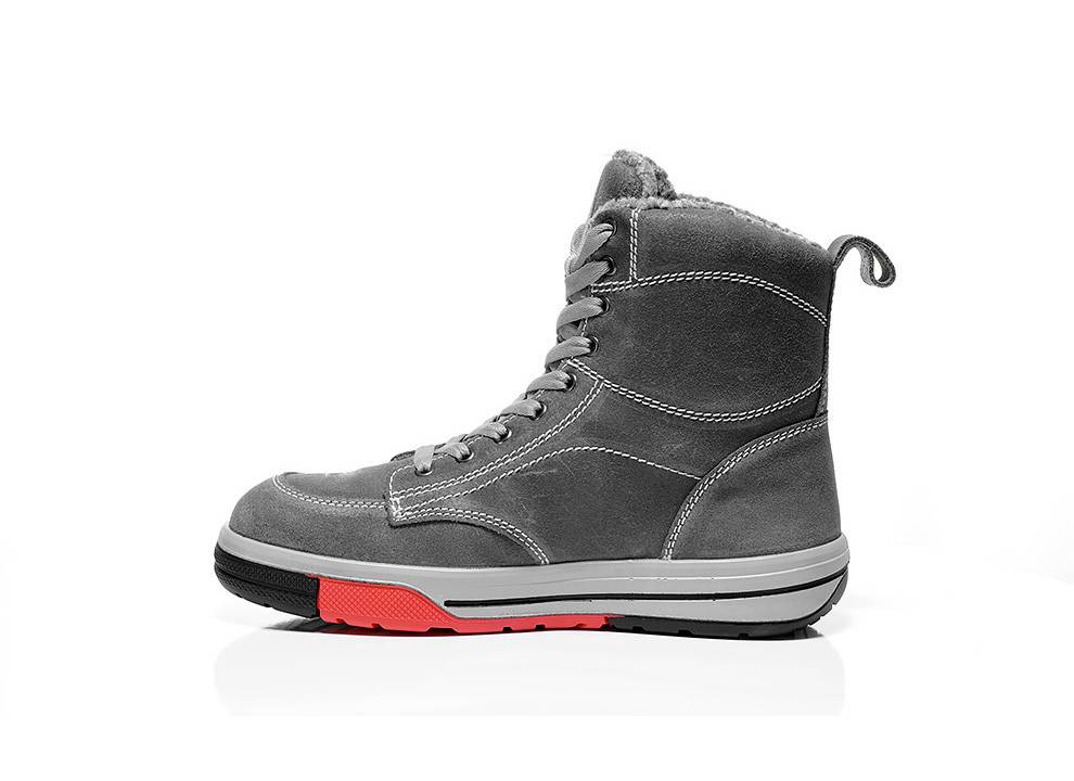 Ein grauer Stiefel mit roter Sohlendetailierung, mit Schnürsenkeln und Knöchelunterstützung, der vor einem weißen Hintergrund präsentiert wird.