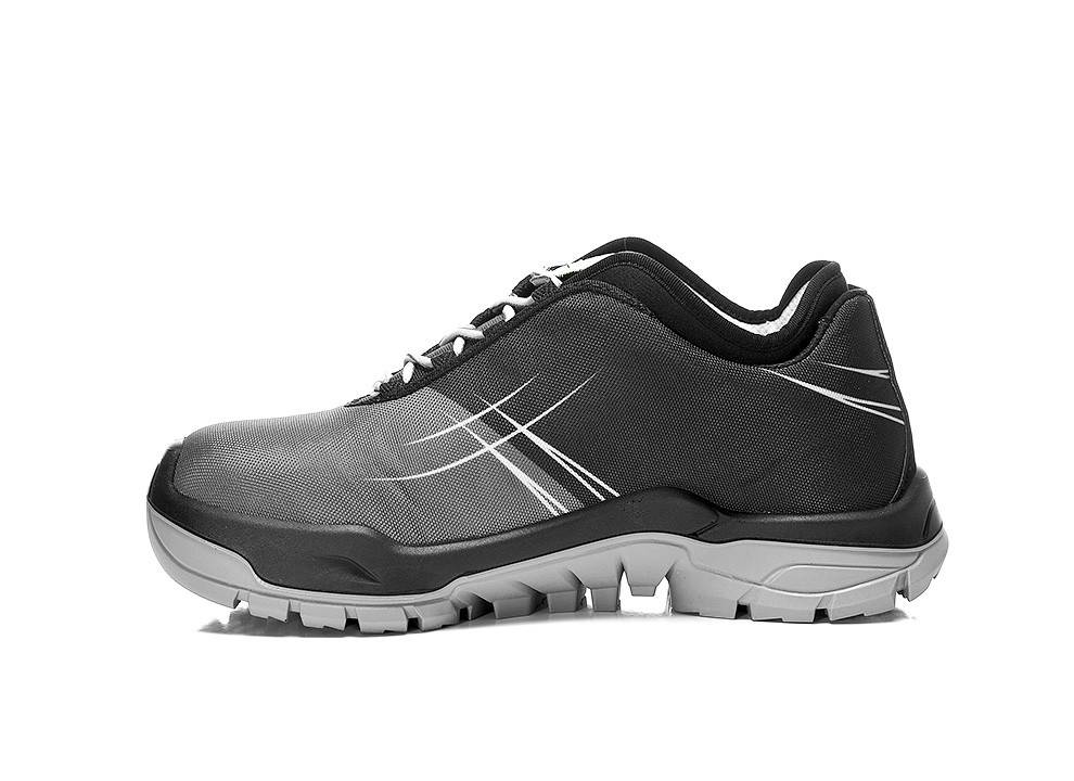 Ein schwarzer und grauer Sportschuh mit weißen Akzenten, mit einer robusten Sohle und Schnürsenkeln, von der Seite betrachtet.
