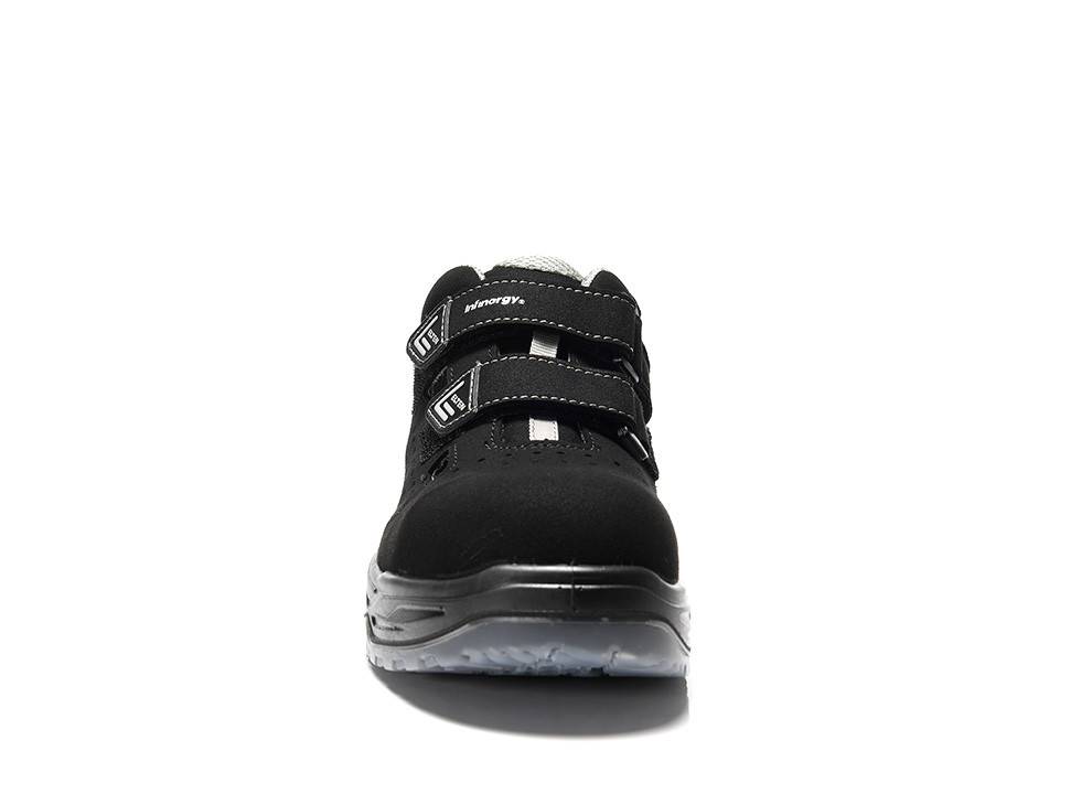 Ein schwarzer Sneaker mit zwei Klettverschlüssen und einer dicken weißen Sohle, von vorne betrachtet.