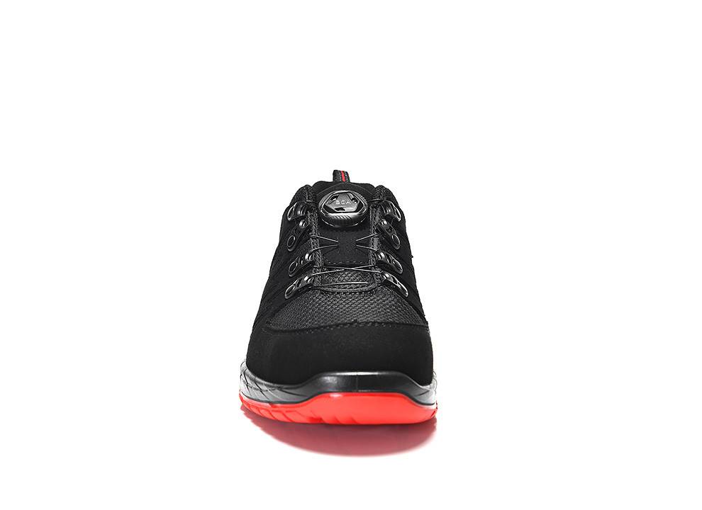 Ein schwarzer Sportschuh mit einer roten Sohle, von vorne betrachtet, mit schwarzen Schnürsenkeln und einem Obermaterial aus Mesh.