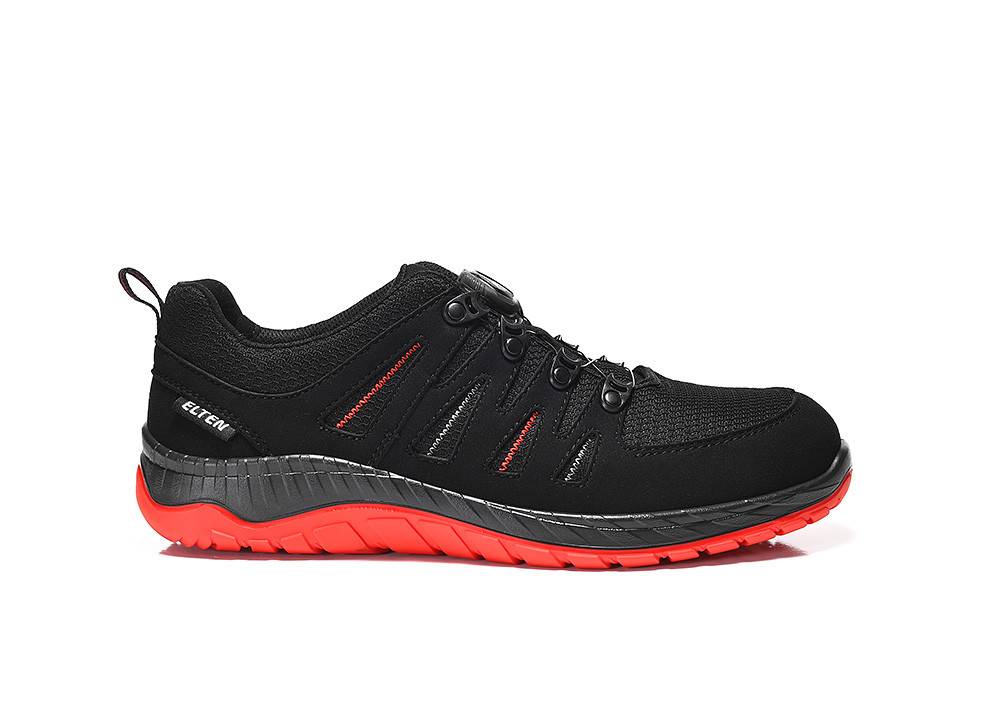 Ein schwarzer Sportschuh mit roter Sohle und schwarzen Schnürsenkeln, versehen mit roter Naht und dem Markennamen an der Seite.