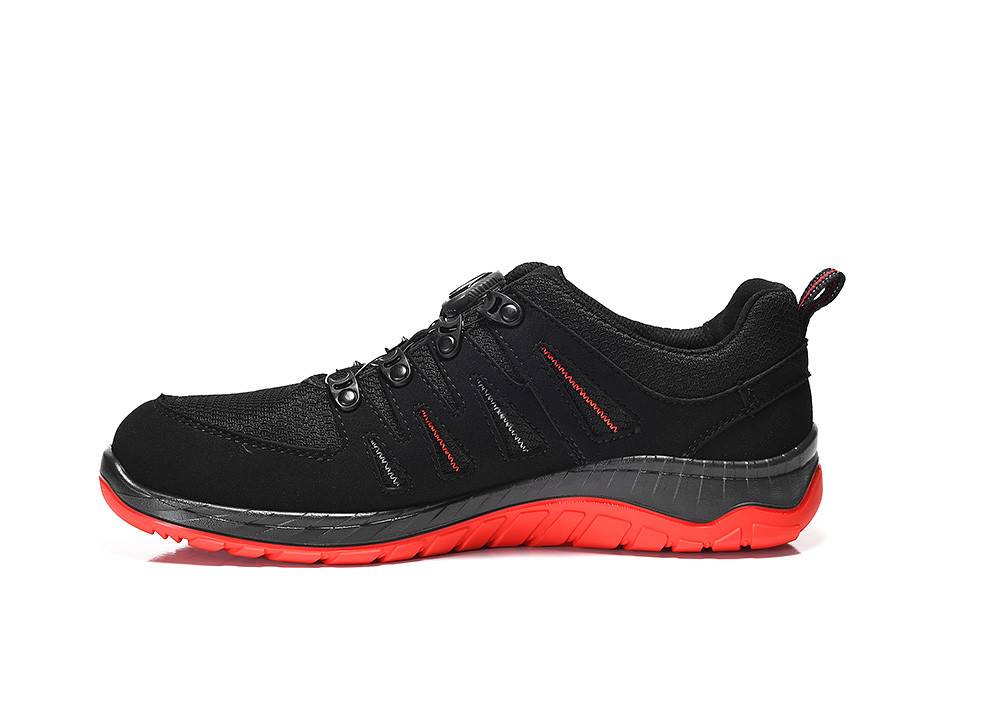 Ein schwarzer Sportschuh mit roter Sohle und roten Nähtedetails, Seitenansicht.