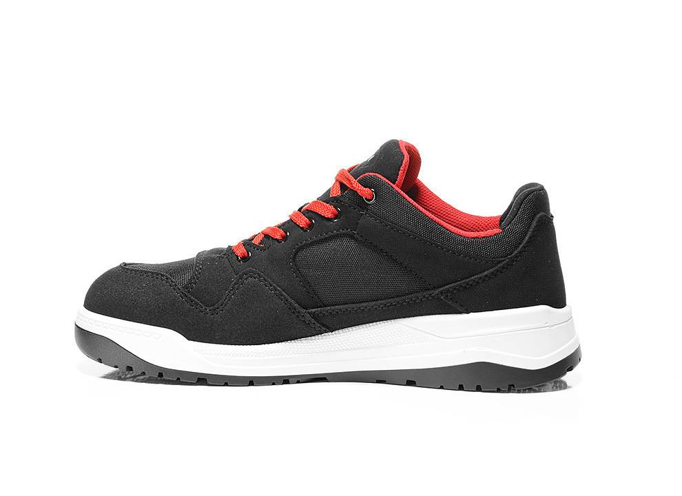 Ein schwarzer Sneaker mit roten Schnürsenkeln und Akzenten auf weißem Hintergrund, mit einer weiß und schwarz gehaltenen Sohle, von der Seite betrachtet.