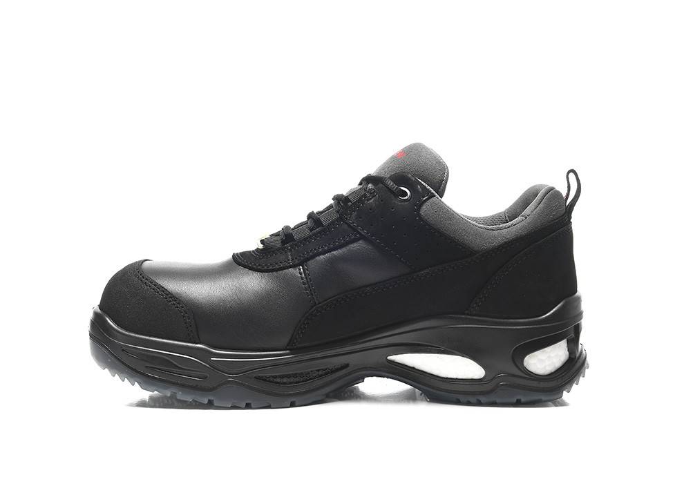 Ein schwarzer und grauer Sportschuh mit einer dicken Sohle wird gezeigt. Der Schuh scheint einen gepolsterten Schaftrand und eine strukturierte, rutschfeste Laufsohle zu haben.