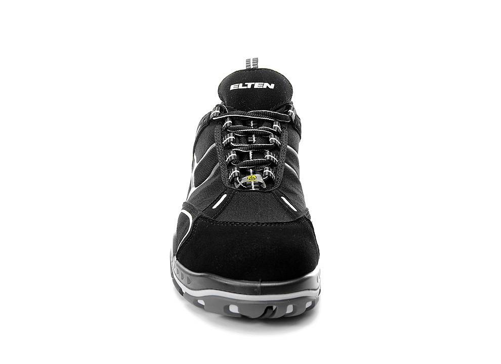 Ein schwarzer und grauer Sneaker, der nach vorne zeigt, mit reflektierendem Material auf den Schnürsenkeln, der Markenname 'Elten' ist auf der Zunge sichtbar.