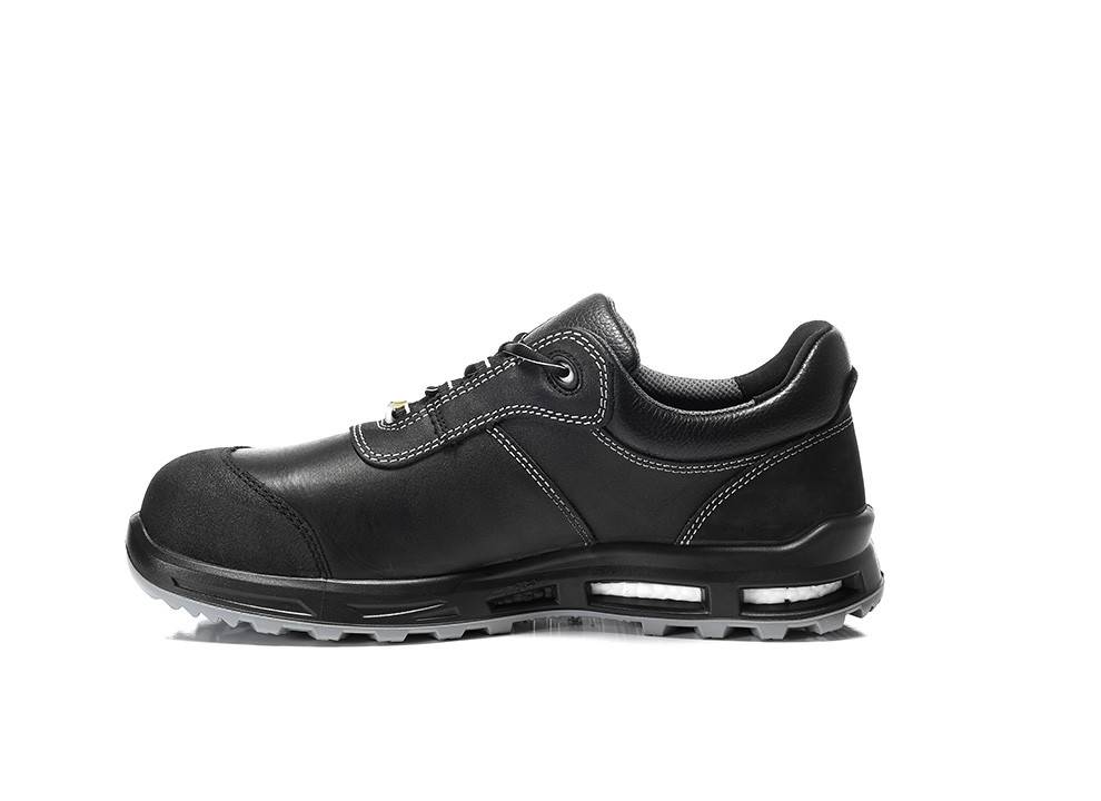 Ein schwarzer Ledersneaker mit weißen Nähten, ausgestattet mit einer dicken Sohle, Luftpolster und Schnürverschluss, auf weißem Hintergrund präsentiert.