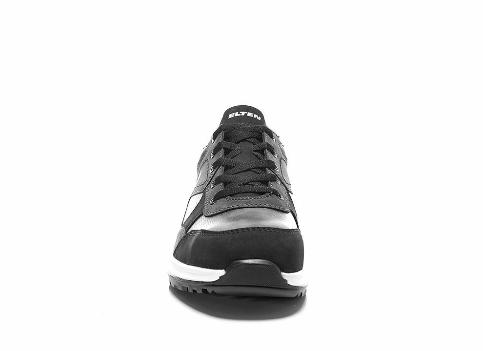 Ein schwarzer und grauer Sneaker mit weißer Sohle, der ein schlankes Design und ein sichtbares Markenlogo auf der Zunge aufweist, von vorne betrachtet.