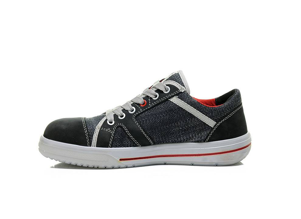 Ein schwarzer und Denim-Sneaker mit weißen Schnürsenkeln und roten Akzenten, mit einer weißen Sohle.