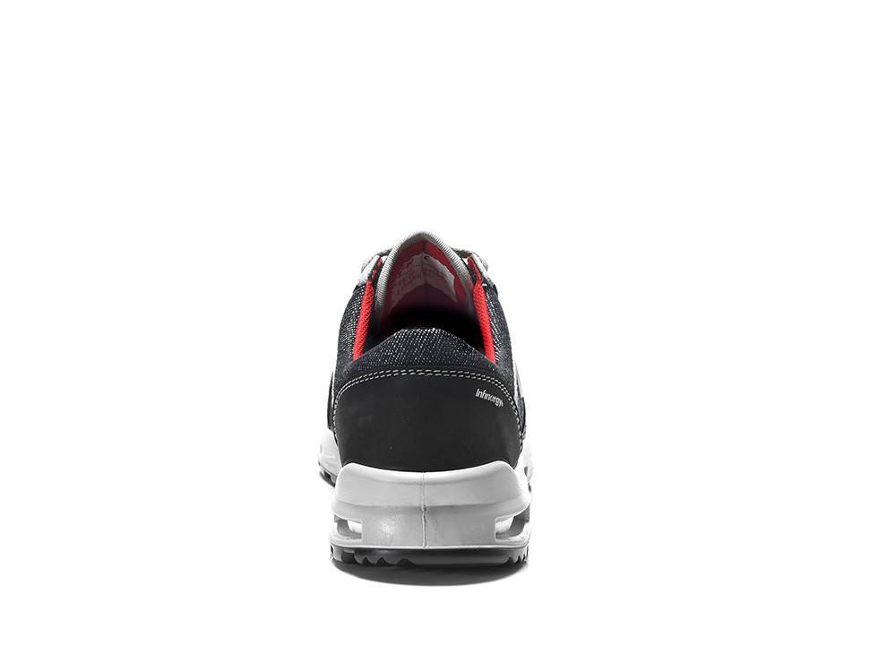 Ein einzelner schwarzweißer Sneaker mit rotem Innenfutter wird von hinten gezeigt und präsentiert das Design von Ferse und Sohle.