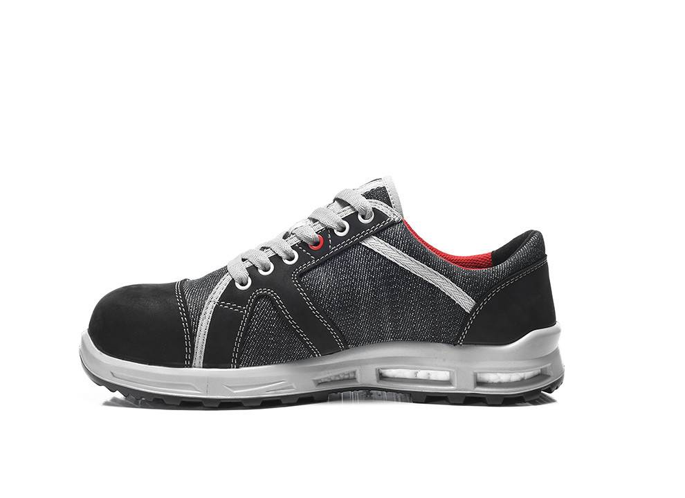 Ein schwarzer und grauer Arbeitsschuh mit roter Fütterung und einer dicken, robusten Sohle, konzipiert für Sicherheit und Haltbarkeit.