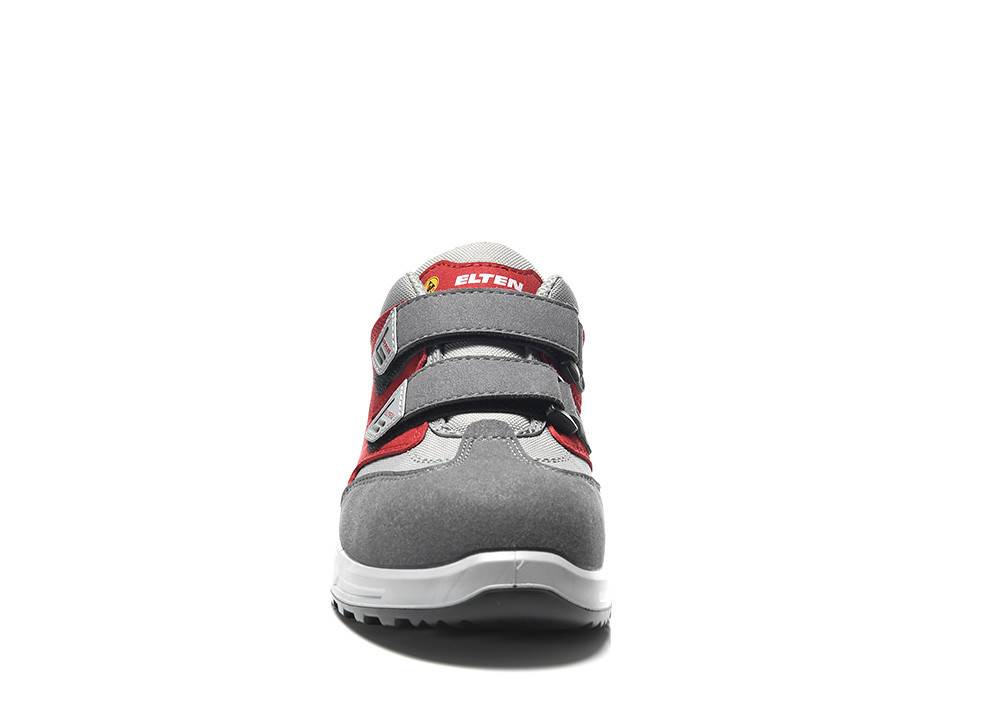 Ein grauer und roter Sicherheitsschuh, von vorne gezeigt, mit einem Klettverschluss zum Befestigen und rutschfester Sohle, der seine Haltbarkeit und sein Design hervorhebt.