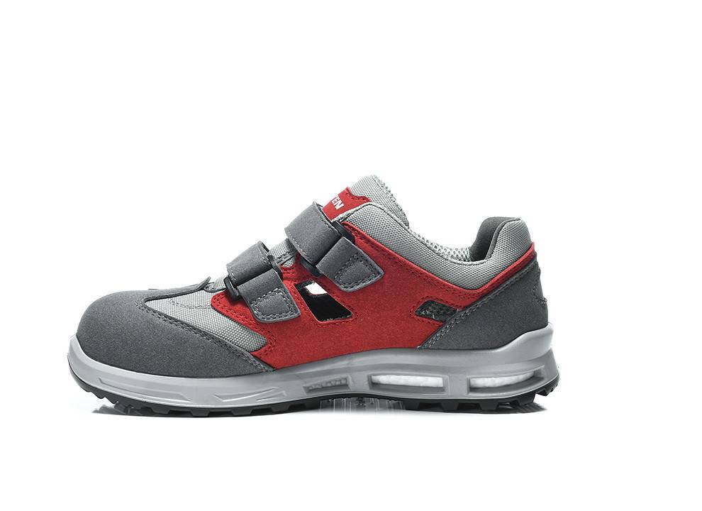 Ein roter und grauer Sportschuh mit zwei schwarzen Klettverschlüssen und einer dicken Sohle, konzipiert für Sport oder aktive Aktivitäten.