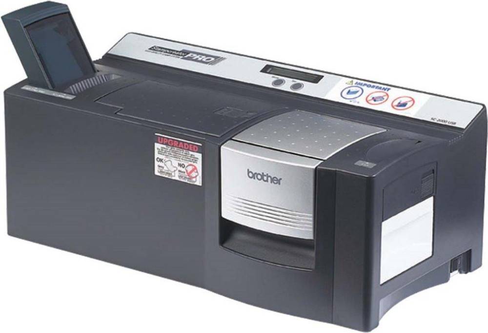 Ein schwarzer und grauer Etikettendrucker mit Brother-Branding, der Bedienknöpfe und einen 