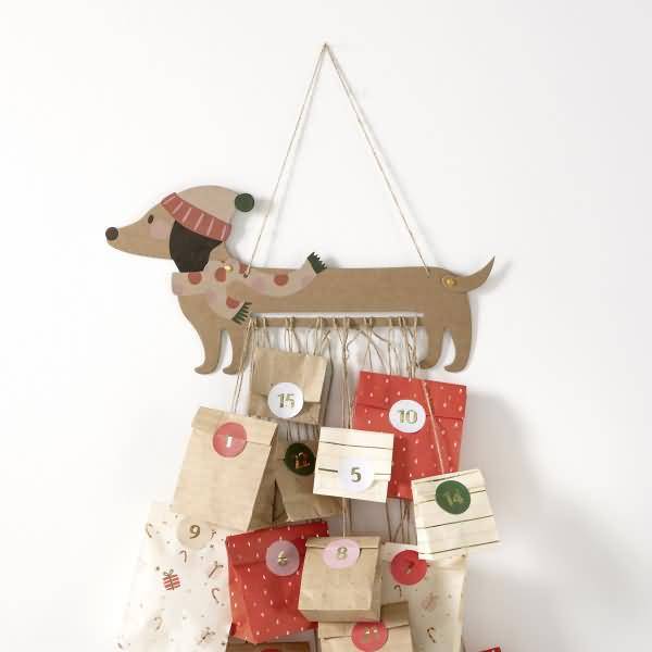 Hundeförmiger Wandbehang-Adventskalender mit nummerierten Papiertaschen, der eine Weihnachts-Countdown-Anzeige suggeriert.