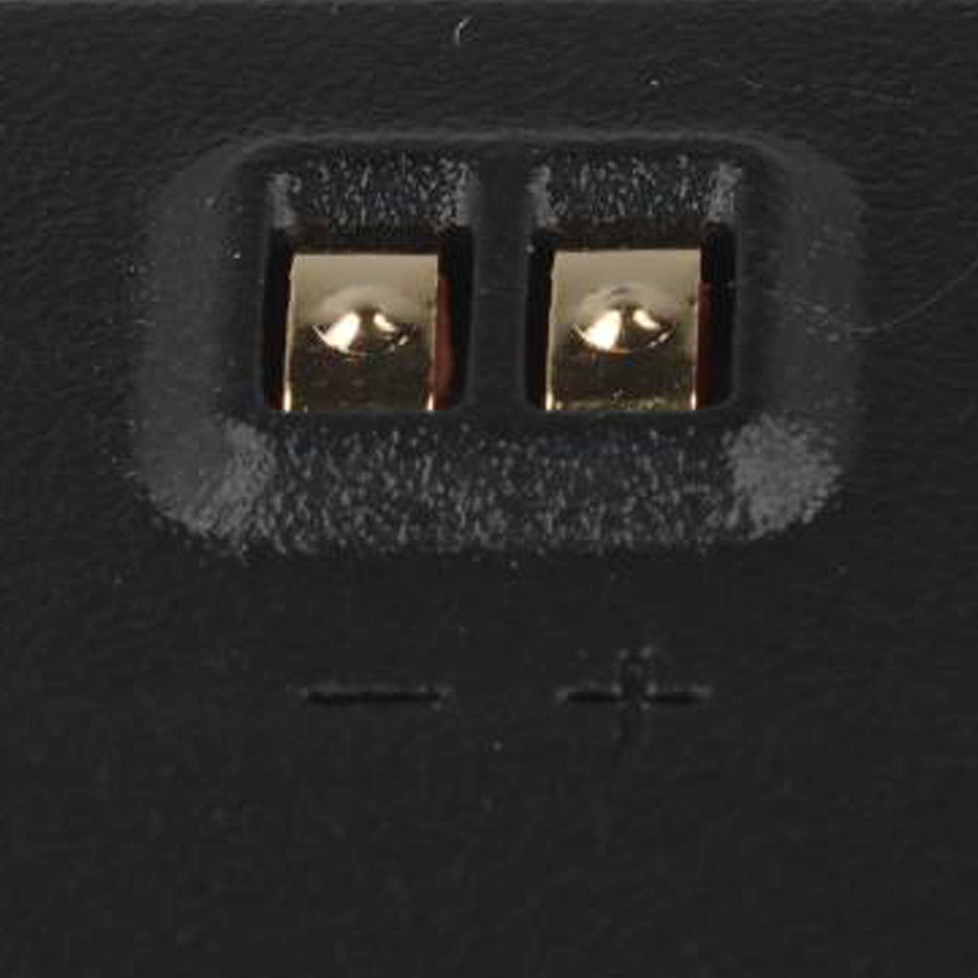 Nahaufnahme eines Batteriefachs mit zwei Metallfedern mit Kontakten, gekennzeichnet mit Minus und Plus.