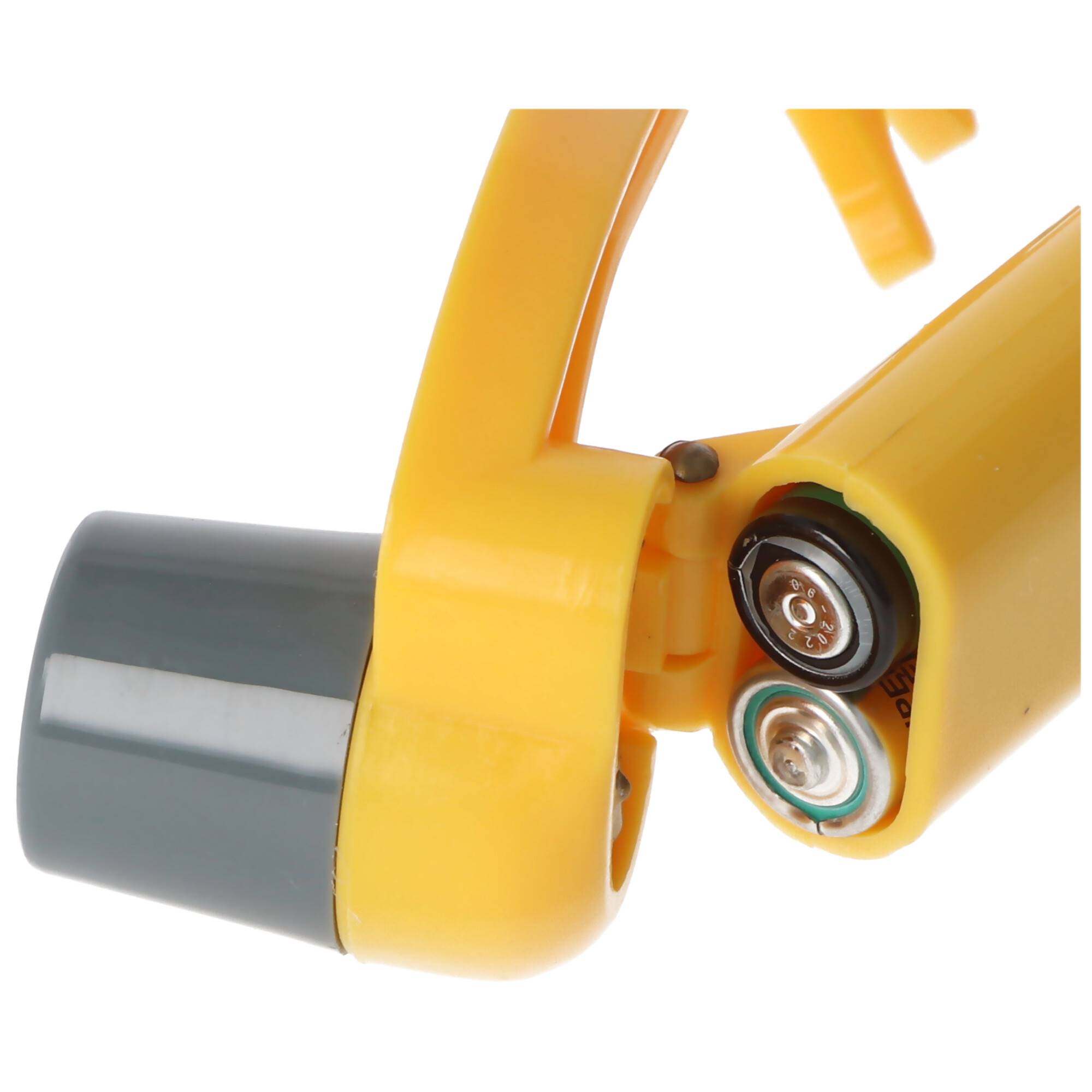 Nahaufnahme eines gelben tragbaren Geräts mit einer Batteriefachklappe, in der zwei sichtbare Batterien und ein angebrachtes graues Bauteil zu sehen sind.
