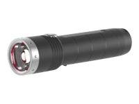 Eine schwarze Taschenlampe mit einem silbernen Ring um die Linse, die horizontal auf einem weißen Hintergrund liegt.