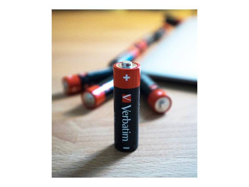 Eine Verbatim AA-Batterie steht aufrecht im Vordergrund, mit mehreren ähnlichen Batterien, die unscharf dahinter auf einer Holzoberfläche zu sehen sind.