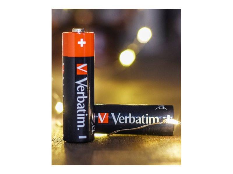 Zwei Verbatim AA-Batterien, eine aufrecht und eine liegend, auf einer reflektierenden Oberfläche mit unscharfen Lichtern im Hintergrund.