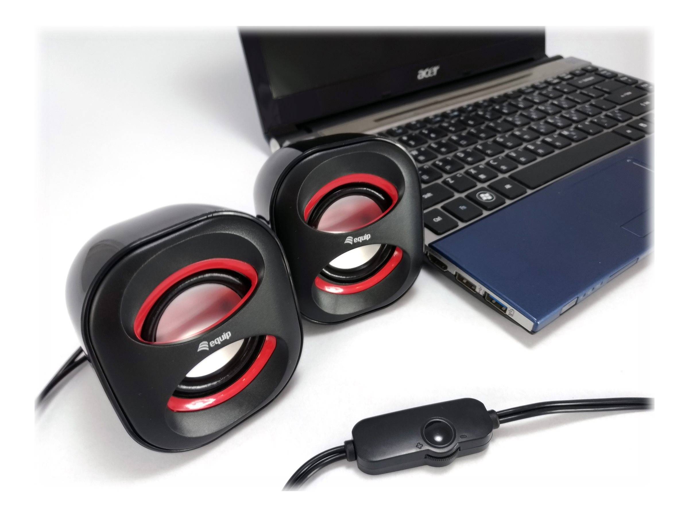 Zwei schwarze Computerlautsprecher mit roten Akzenten neben einem Acer-Laptop, mit einer Lautstärkeregelung am Kabel.