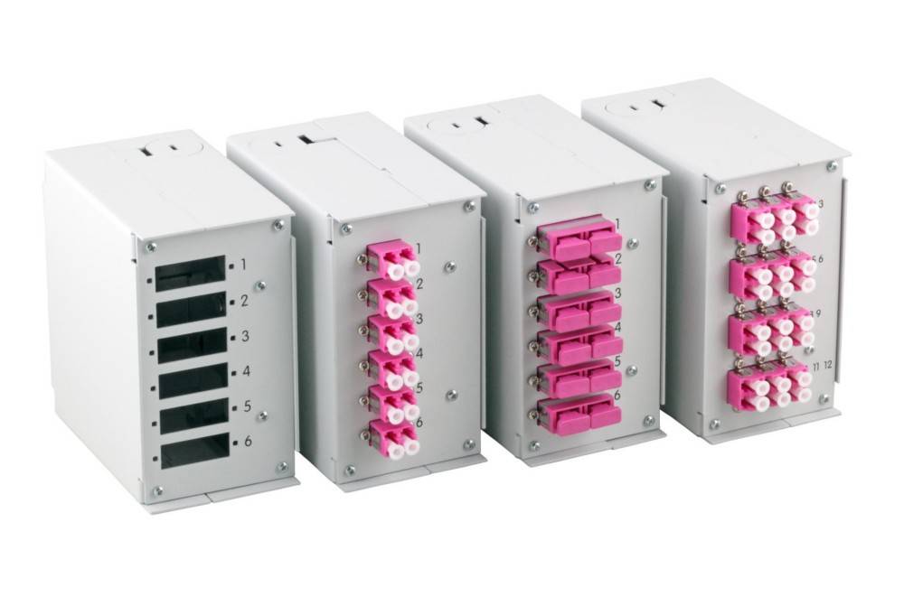 Vier modulare Netzwerk-Glasfaser-Patchpanels mit nummerierten Ports und rosa Anschlüssen, in einer Reihe angeordnet, zur Verwaltung von Glasfaserkabeln.
