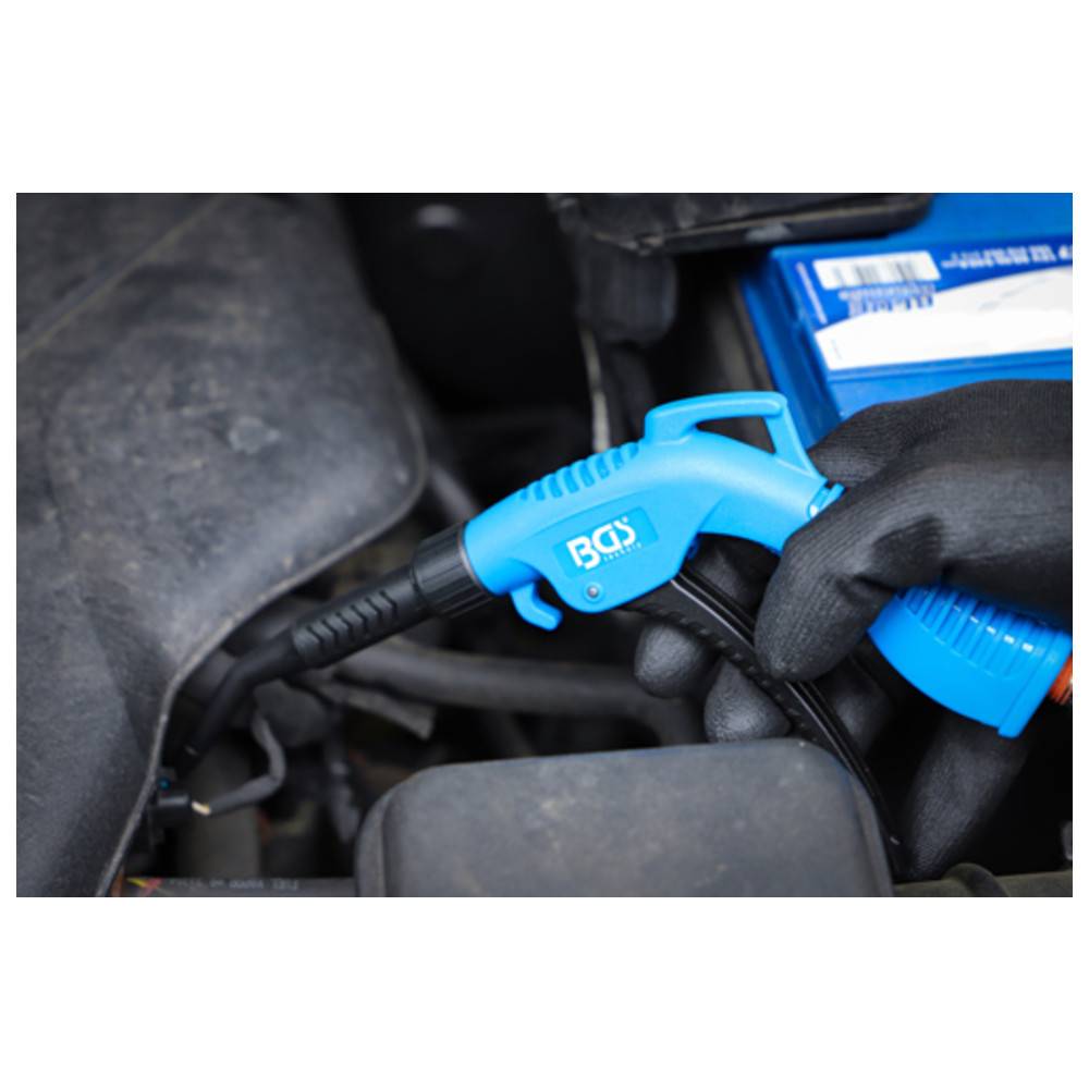 Eine schwarzhandschuhbehandschuhte Hand verwendet eine blaue Druckluftpistole, um Motorkomponenten eines Fahrzeugs zu reinigen, was auf Wartungs- oder Reinigungsarbeiten hinweist.