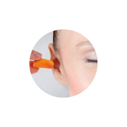 Eine Person steckt einen orangefarbenen Ohrstöpsel in ihr Ohr zum Gehörschutz.