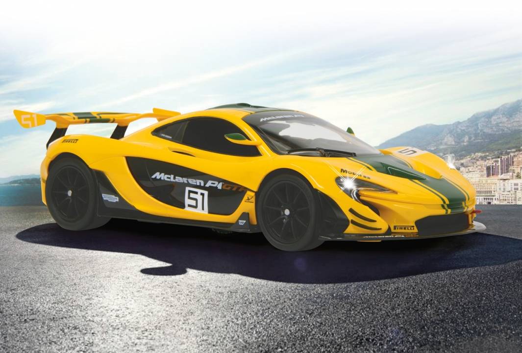 Gelber McLaren P1 Rennwagen, Nummer 51, geparkt auf einer Bergstraße mit einer Küstenstadt und Hügeln im Hintergrund.