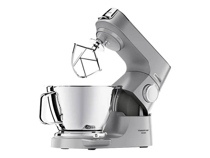 Silberfarbener Standmixer mit angebrachter Rührschüssel und Drahtquirl-Aufsatz auf weißem Hintergrund.