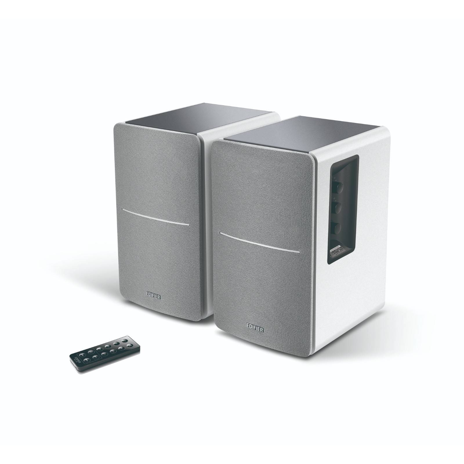 Zwei aufrechte rechteckige Lautsprecher mit grauen Fronten und weißen Seiten; eine schwarze Fernbedienung liegt davor.