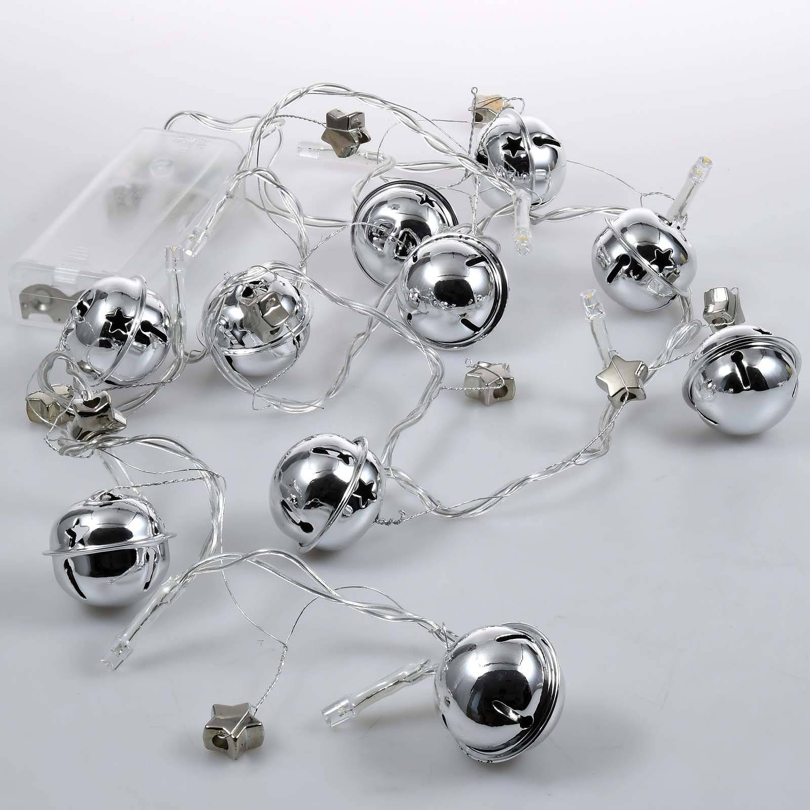 Silberne Glöckchen-Lichterkette mit sternförmigen Akzenten, verschlungen auf einer weißen Oberfläche.