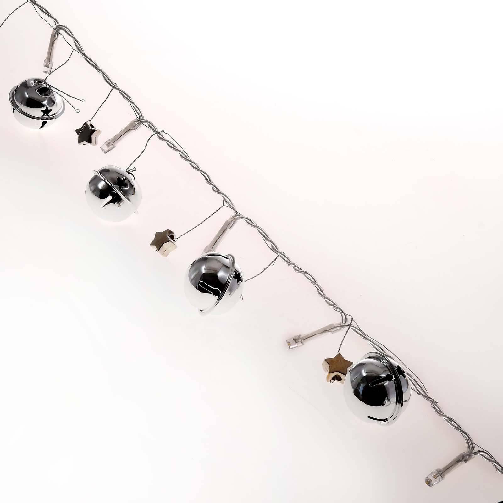 Silberne Weihnachtslichterketten mit hängenden glockenförmigen Ornamenten und Sternanhängern auf weißem Hintergrund.