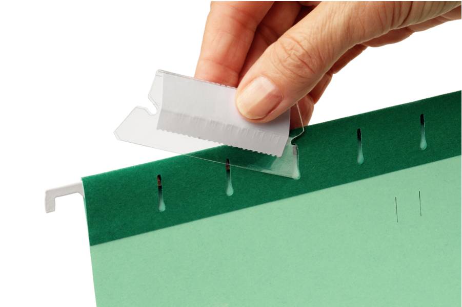 Hand, die einen weißen Reiter in die Oberseite eines grünen Hängordners auf schwarzem Hintergrund einfügt.