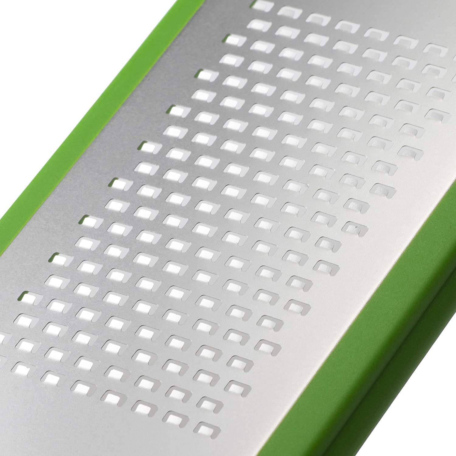 Nahaufnahme einer Metallreibe mit grünem Griff mit Reihen von quadratischen Perforationen auf einer silbernen Oberfläche.