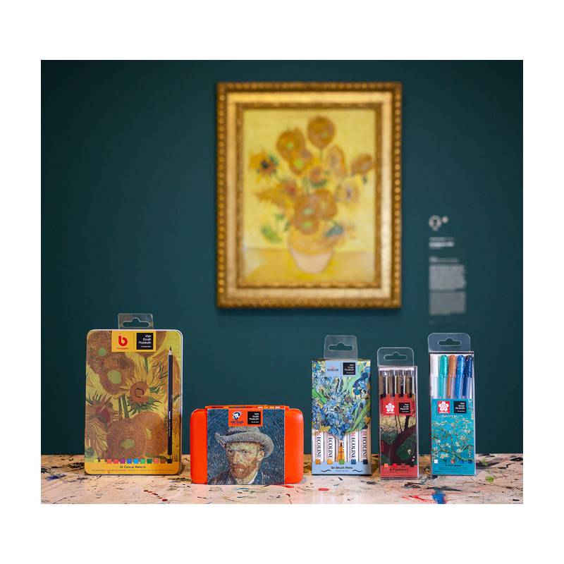 Künstlerische Materialien werden auf einem Tisch ausgestellt, vor dem Hintergrund eines Sonnenblumengemäldes in einer Galerie, wobei künstlerische Inspiration hervorgehoben wird.