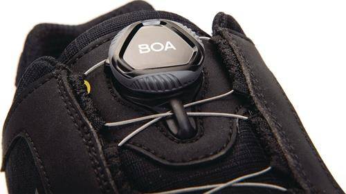 Nahaufnahme eines Schuhs mit BOA-Drehverschluss und Schnürsystem, entwickelt für einfache Verstellung. Der Fokus liegt auf dem Drehverschlussmechanismus und den Schnürsenkeln.