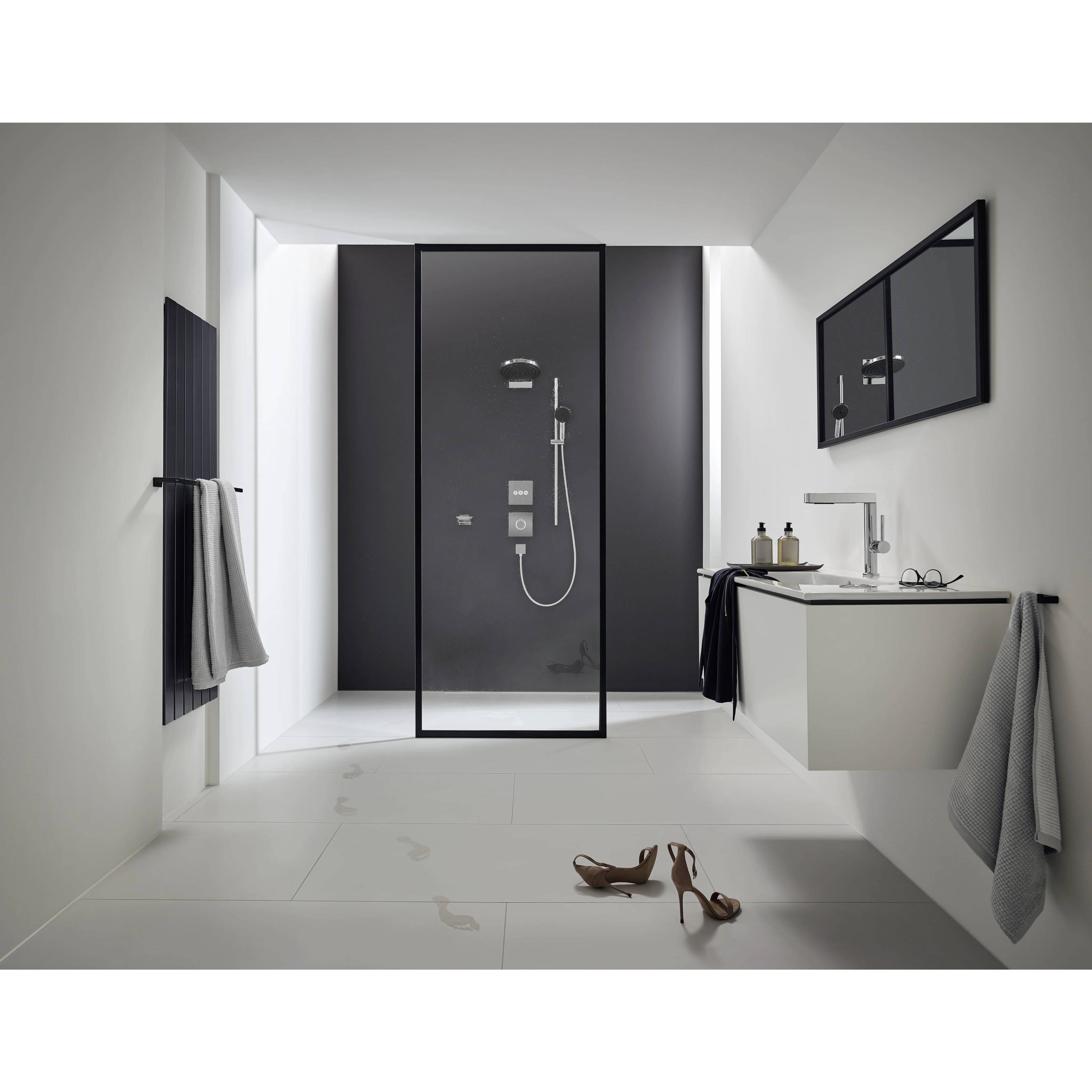 Modernes Badezimmerinnere mit begehbarer Dusche, schwebendem Waschtisch, Wandspiegel, Handtüchern und Schuhen auf dem Boden.