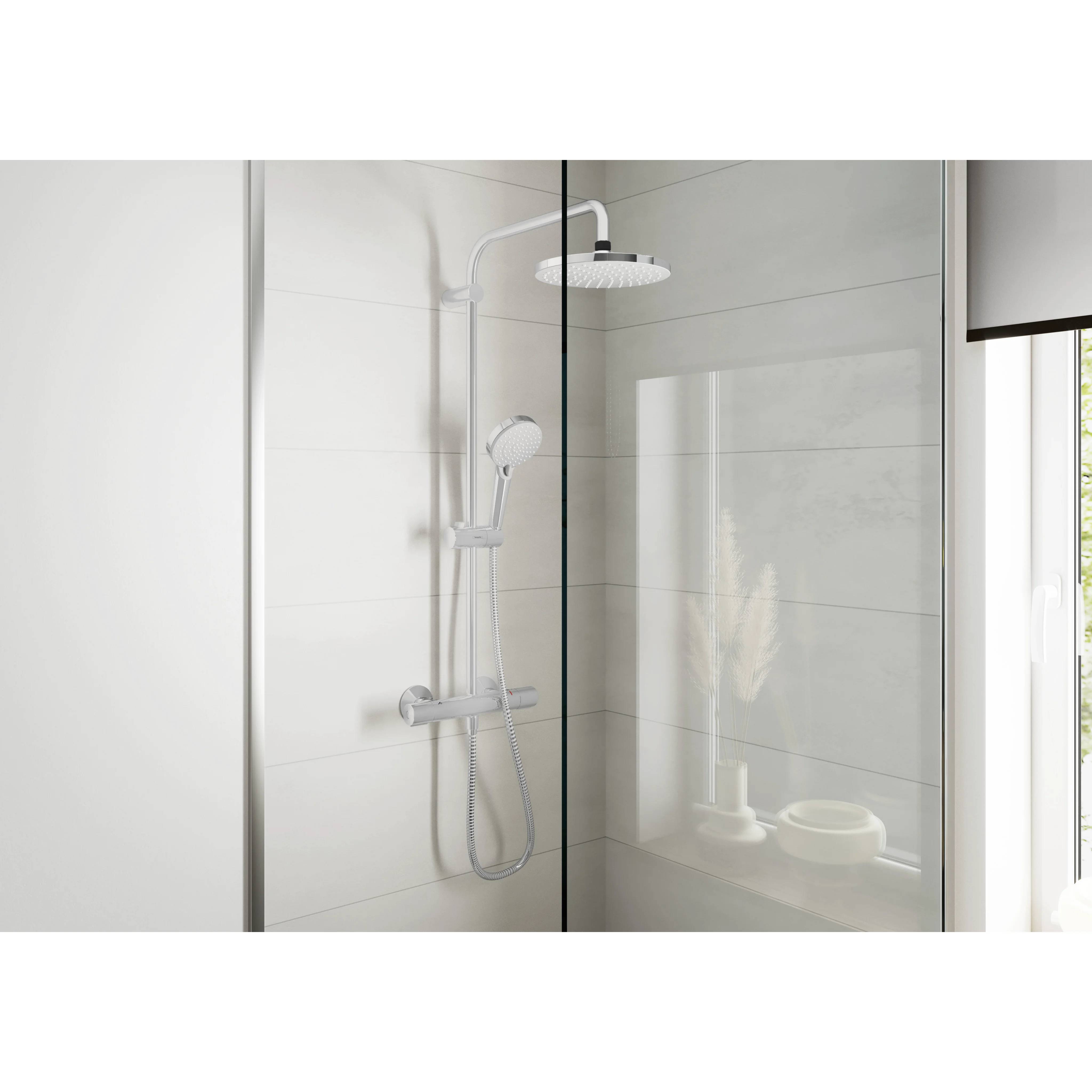 Modernes Badezimmer mit Glasummantelung, wandmontiertem Regenduschkopf, Handbrause und weiß gefliesterem Innenraum in einem hellen Badezimmer.