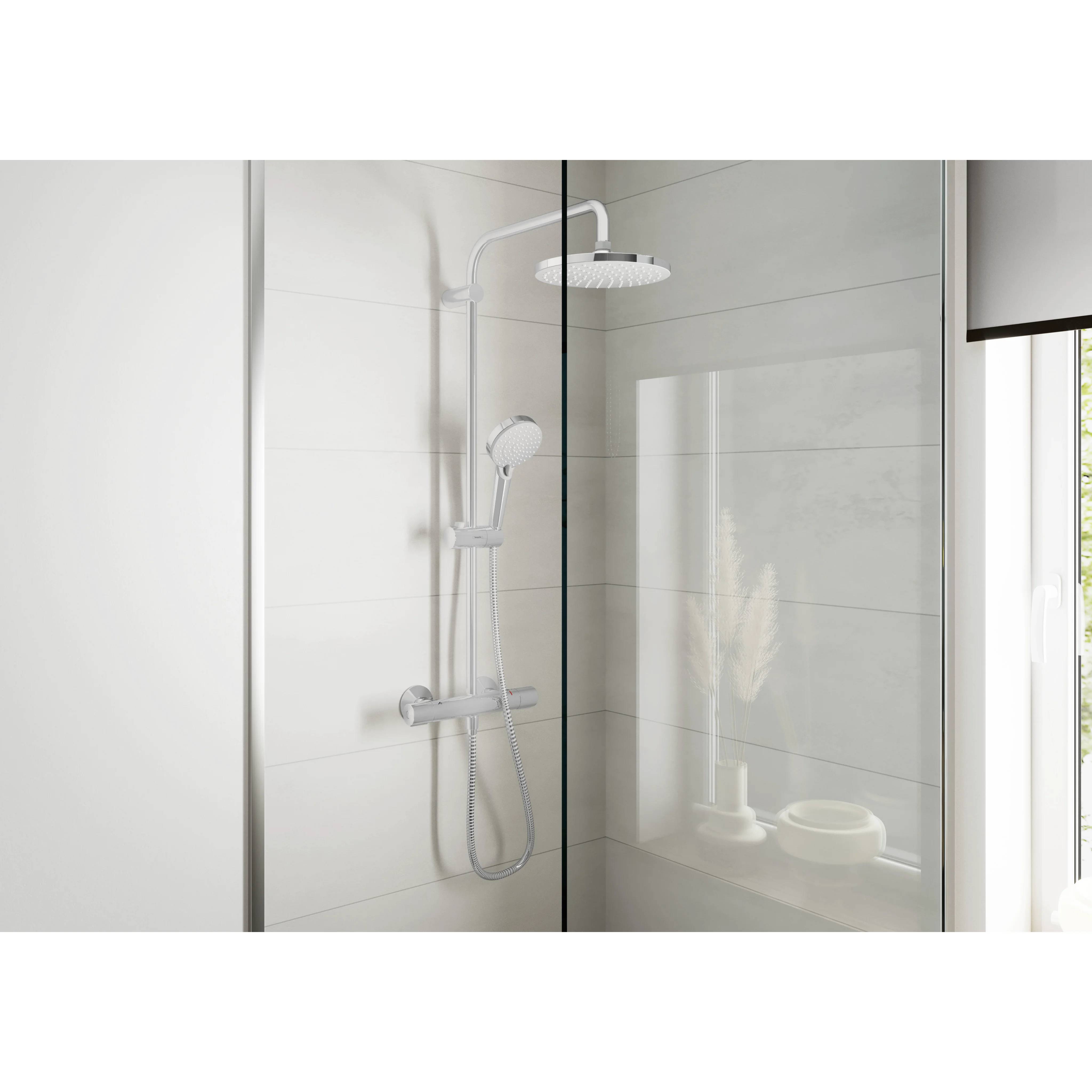 Moderne Duschkabine mit Glaseinfassung, an der Wand montiertem Duschkopf, tragbarem Handbrausekopf und weißen gefliesten Wänden in einem hellen Badezimmer.