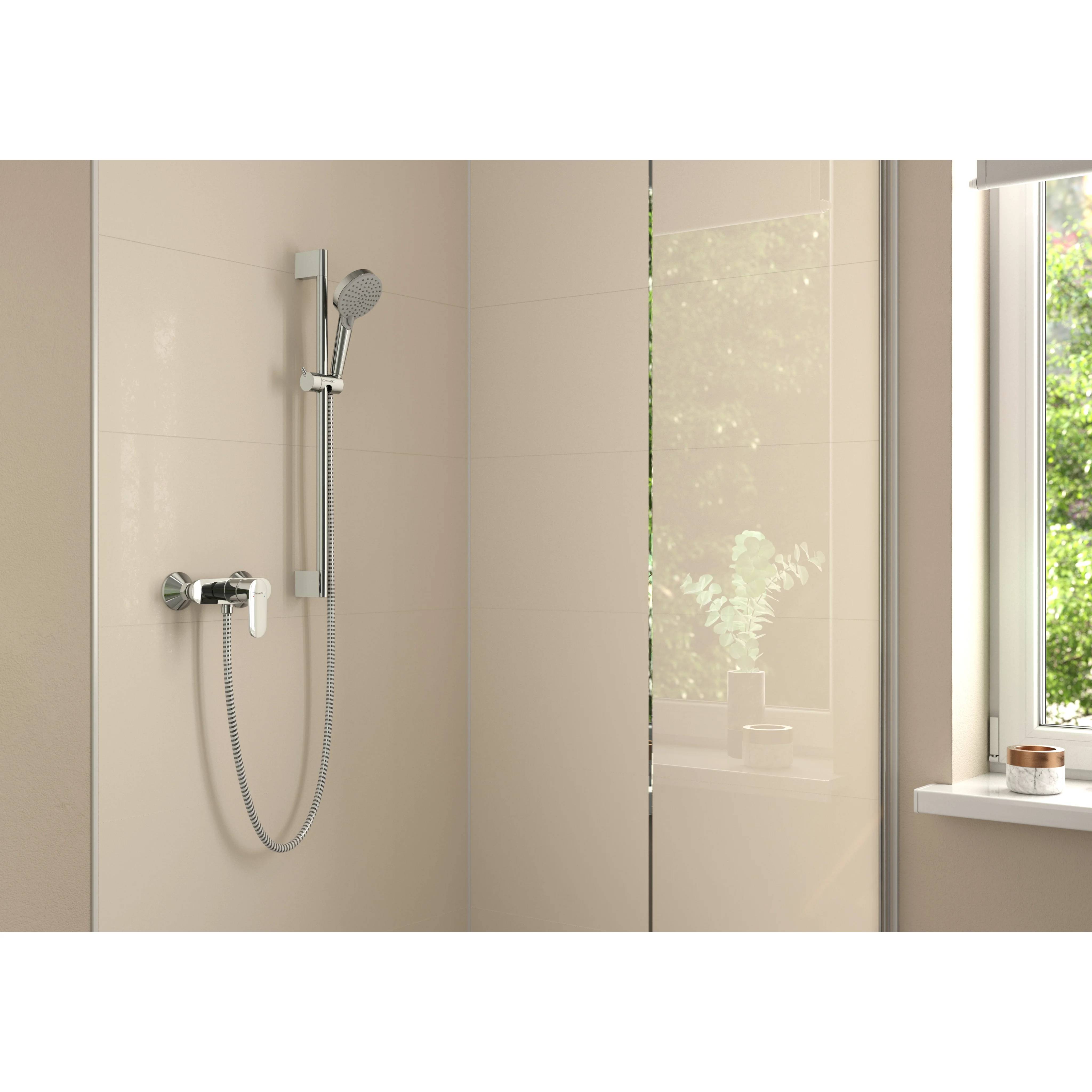 Modernes Badezimmer mit verchromtem Handbrausekopf und Schlauch, montiert an einer beigefarbenen gefliesten Wand neben einer Glaspaneel und einem Fenster.